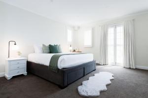 ローンセストンにあるModern 3-Bedroom House in Vibrant Neighborhoodの大きなベッドと窓のある白い寝室