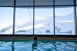 a person in a swimming pool in a ski resort at Résidence Azureva Piau Engaly in Aragnouet