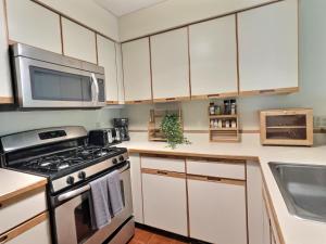 a kitchen with a stove and a microwave at SugarBear- Pool, AC, Sauna, Gym, Tennis in Killington