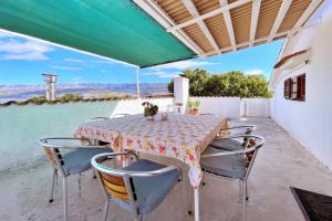 a table and chairs on a patio with a green roof at Apartments Srdoc in Šilo