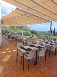 a group of tables and chairs under a large umbrella at Hostal Ondina in Begur