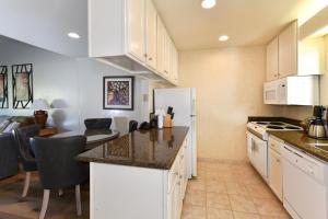 a kitchen with white cabinets and a living room at 656 Cottages at Silverado condo in Napa