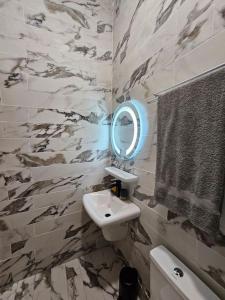 a bathroom with a sink and a mirror at L'appart D' LJ in Cotonou +25 photos
