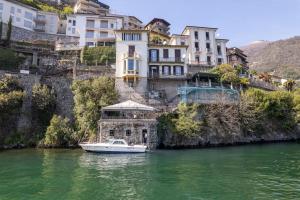 アルジェーニョにあるStorica Villa sul Lago di Como con darsena privataの建物前の水上船