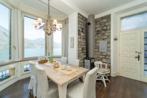 アルジェーニョにあるStorica Villa sul Lago di Como con darsena privataのテーブルと椅子とシャンデリアのあるダイニングルーム
