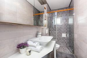 biała łazienka z umywalką i prysznicem w obiekcie Apartment Presker w mieście Šilo