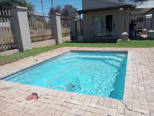 a swimming pool with a hose in a yard at Kuruman Hotel in Kuruman