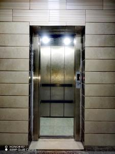 a elevator in a building with a glass door at Farah Plaza Hostel &Hotel Apartments in Aqaba