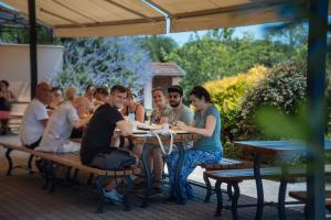 a group of people sitting at a picnic table at Gurudeva Bhavan in Somogyvámos