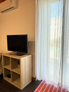 a television sitting on a stand next to a window at Casa Claudia in Salerno