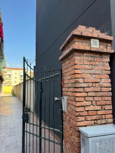 a brick wall with a gate with a sign on it at Casa Claudia in Salerno