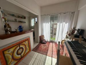 une chambre avec un piano et un salon dans l'établissement Departamento centro Mar del Plata-1 cuadra del mar- monoambiente-balcón calle., à Mar del Plata 3 autres photos