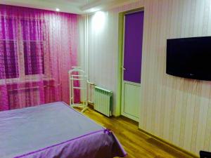 a room with a bed and a flat screen tv at VIP apartment in Cherkasy