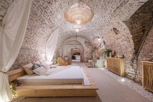 a bedroom with a bed in a stone wall at Aura Spa in Vilnius