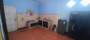 a kitchen with a refrigerator and a wooden floor at Natiga Guest House in Giri