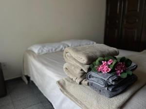uma pilha de toalhas e flores numa cama em Apartamento Imperial em bairro Premium região calma e central em Manaus