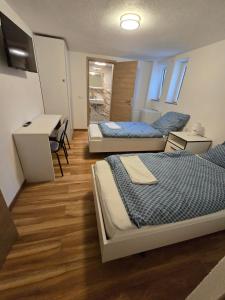 a room with two beds and a desk in it at Pension Hirsch in Berg