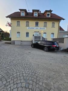 a black car parked in front of a building at Pension Hirsch in Berg