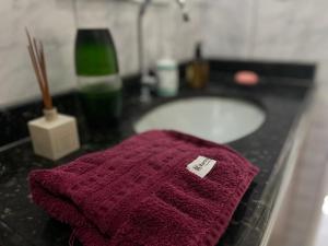 uma toalha vermelha sobre a bancada do banheiro com uma pia em Apartamento Imperial em bairro Premium região calma e central em Manaus mais 50 fotografias
