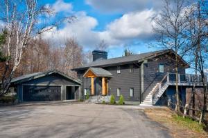 a gray house with a staircase in the driveway at VIEWS, Hot Tub, Sauna, Theatre in Conway