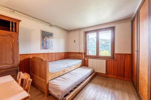 una camera da letto con due letti a castello e una finestra di Chalet L'Abri - Pour 9 avec vue montagne a Saint-Nicolas-la-Chapelle