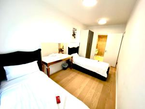 una camera con due letti, una scrivania e un lavandino di Nova Sky a Berlino