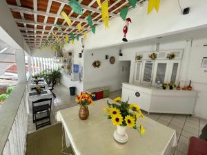 a room with a table with flowers on it at Hospedagem São Francisco in São Luís