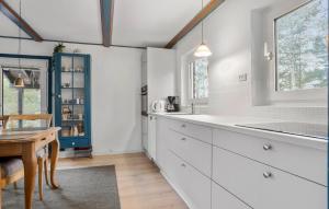 Una cocina con gabinetes blancos y una mesa de madera. en Holiday Home Rislumvej Rømø Ix, en Rømø Kirkeby