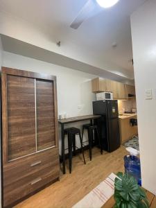 a kitchen with a table and a black refrigerator at 1 BR Condo with balcony in Verdon Parc Trevans 512 in Davao City