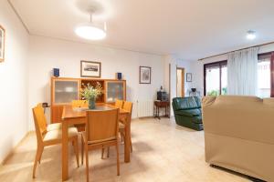 a dining room and living room with a table and chairs at Global Properties, Apartamento muy cerca de la playa de Puerto de Sagunto in Puerto de Sagunto