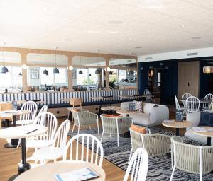 a restaurant with white chairs and tables at Ty Ys Hôtel in Audierne