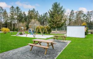 un parc avec deux tables de pique-nique et une aire de jeux dans l'établissement Beautiful Apartment In Nexø With Sauna, à Strandby Gårde