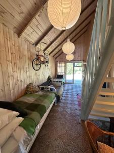 a room with a couch in a house with a bike on the ceiling at Rustic Barn by the Bay in Low Head