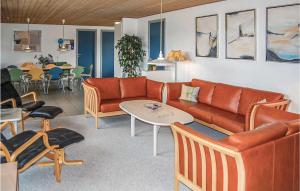 a living room with a couch and a table and chairs at Holiday Home Søren Lassens Vænge Blåvand Denm in Blåvand