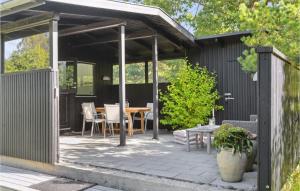a covered patio with a table and chairs at 2 Bedroom Nice Home In Vejby in Vejby +10 photos