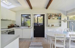 a kitchen with a white table and a black door at 2 Bedroom Nice Home In Vejby in Vejby