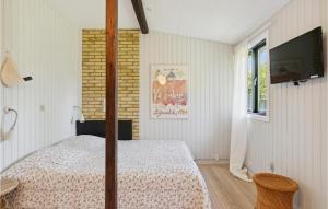 a bedroom with a bed and a flat screen tv at 2 Bedroom Nice Home In Vejby in Vejby