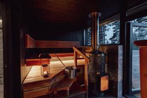 Eine Hütte mit Veranda, auf der ein Ofen und ein Fenster stehen in der Unterkunft Saunamäki - Cedra in Salo + 16 Fotos