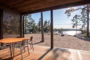 einen Tisch und Stühle auf einer Terrasse mit Blick auf den Strand in der Unterkunft Saunamäki - Cedra in Salo