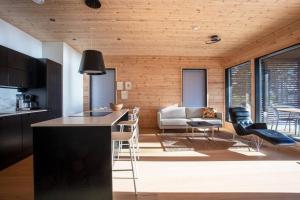 eine Küche und ein Wohnzimmer mit Tisch und Stühlen in der Unterkunft Saunamäki - Cedra in Salo