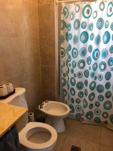 a bathroom with a toilet and a shower curtain at El Siambon Los Aromos in Siambón