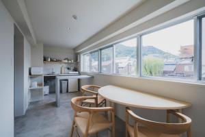 a kitchen with a table and chairs and a window at nine stories hotel in Kotohira