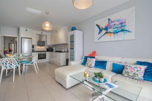 ein Wohnzimmer mit einer weißen Couch und einem Tisch in der Unterkunft Apartment Octopus in Moraira