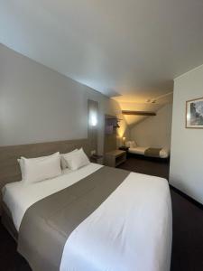 a large white bed in a hotel room at Kyriad Saint Fargeau Ponthierry - Apollonia in Saint-Fargeau-Ponthierry +44 photos