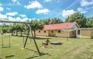 a swing set in a yard in front of a house at Three-Bedroom Holiday Home In Oksbol in Oksbøl