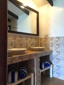 een badkamer met 2 wastafels en een grote spiegel bij Casa Amihan in Anda