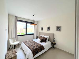 a bedroom with a bed and a chair and a window at Maison Belmonte Las Vistas Altaona Golf in Baños y Mendigo +78 photos