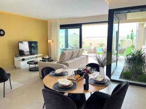 a living room with a table and chairs and a couch at Maison Belmonte Las Vistas Altaona Golf in Baños y Mendigo