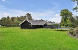 a black house with a ping pong table in the yard at Holiday Home Bjergbovej Blåvand Denm in Blåvand +20 photos