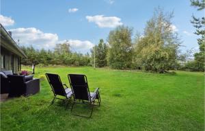 due sedie sedute nell'erba in un cortile di Three-Bedroom Holiday Home In Jerup a Jerup Altre 10 foto